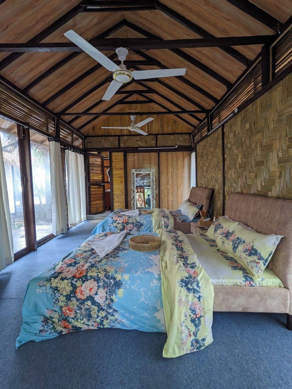 A spacious room with a large bed, a ceiling fan, and a view of the outdoors.