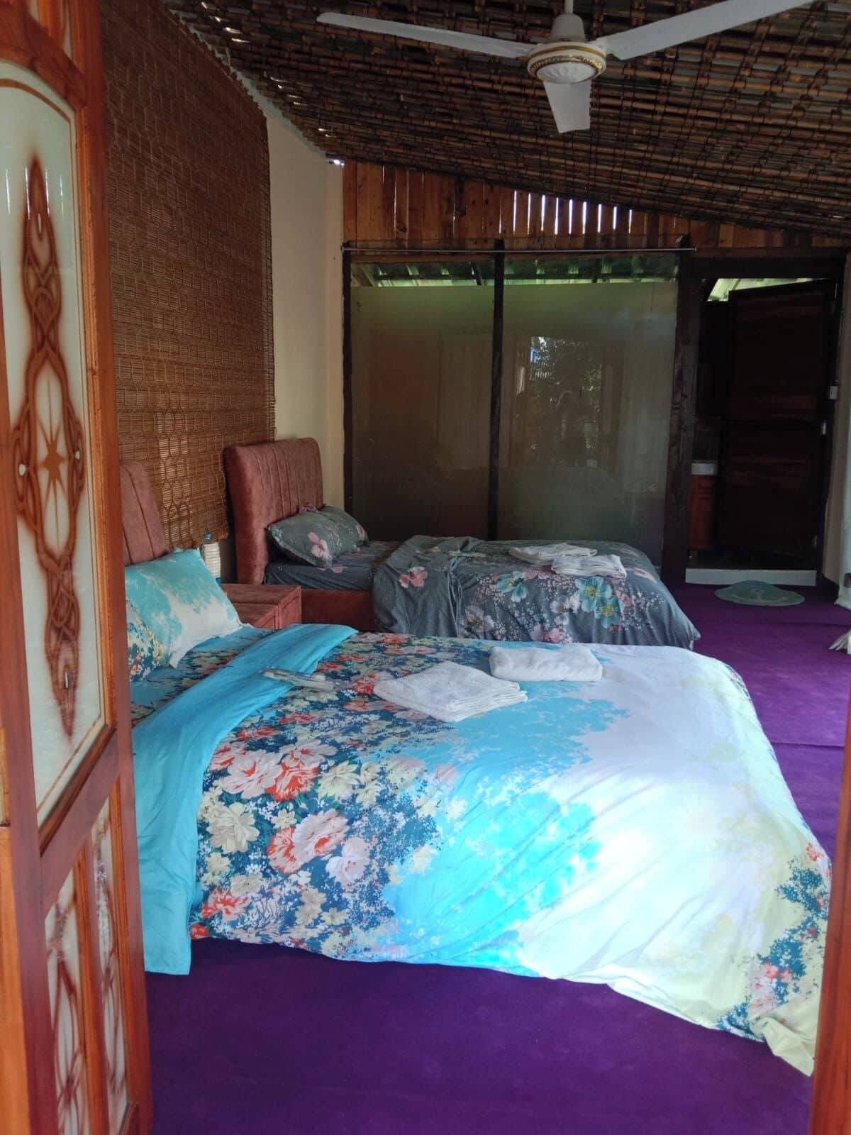 Een slaapkamer met een bed, een stoel en een plafondventilator.