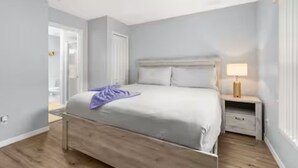A bedroom with a bed, bedside table, and a lamp. - Spacious 5-bedroom Family Escape - Disney - Private Pool - BBQ (Davenport)