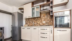 A modern kitchen with stainless steel appliances, white cabinetry, and a tiled backsplash. - Amazing Villa With Outdoor Swimming Pool (Stankovci)