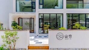 A modern building with a white facade, large windows, and a logo with Chinese characters.