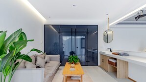 A modern living room with a sofa, a wooden coffee table, and a potted plant.