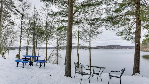 A lakeside seating area with a table and chairs, surrounded by trees and snow. - All-Season Lake Wallenpaupack Condo w/ Views (Greentown)