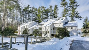 A row of white buildings with a sloped roof, surrounded by snow and trees. - All-Season Lake Wallenpaupack Condo w/ Views (Greentown)