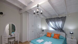 Un dormitorio con cama, cómoda, espejo, armario y candelabro.
