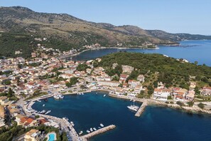 An aerial view of a coastal town with a marina, surrounded by hills and clear blue waters. - The Doctor's House- Vacation house in Kassiopi, Corfu (Kassiopi)