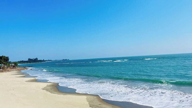 Ein Strand mit klarem, blauem Wasser und einem Sandufer.