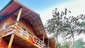 Ein Holzhaus mit Balkon, einem Rettungsring und einer Treppe zum Eingang.