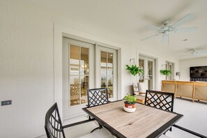A dining area with a table, chairs, and potted plants. - Beautiful Garden Villa with Golf Cart Option (Sumterville)
