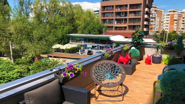 A rooftop terrace with outdoor seating, potted plants, and a view of surrounding buildings. - "Relax Cluj Apartment" by Interhome (Cluj-Napoca)