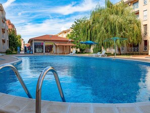 Ein Schwimmbecken mit freiem Blick auf den Poolbereich, einschließlich Liegestühlen und Sonnenschirmen.