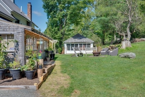 A house with a covered porch, a small shed, and a grassy yard with trees. - Green Mountain Views! Lowell Getaway Near Skiing (Lowell)