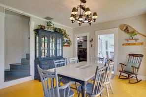 A dining area with a large table, chairs, a blue cabinet, and a chandelier. - Green Mountain Views! Lowell Getaway Near Skiing (Lowell)