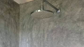 A shower with a handheld showerhead and a wall-mounted faucet.