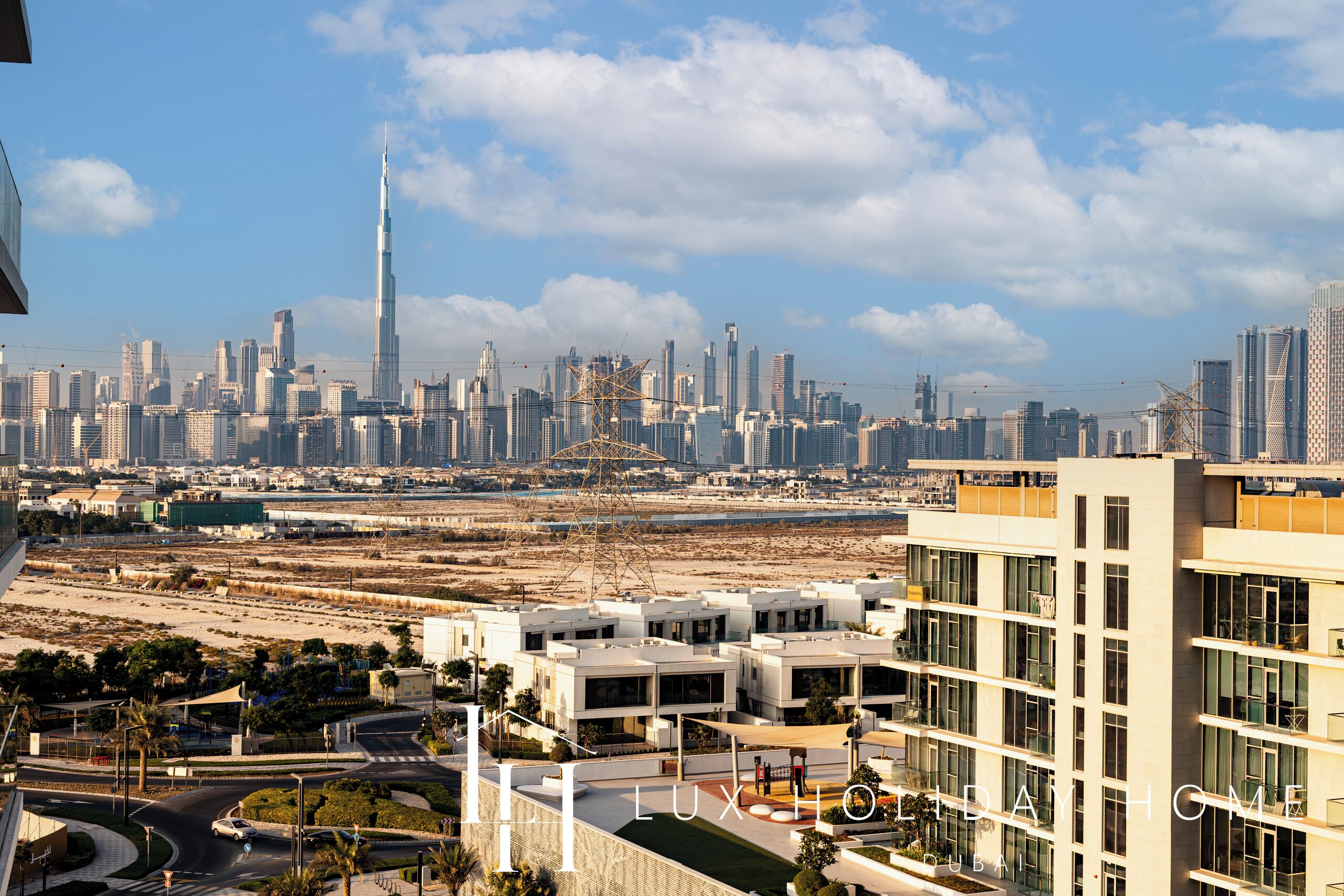 A modern building with a rooftop terrace, surrounded by a cityscape with high-rise buildings and a clear sky.