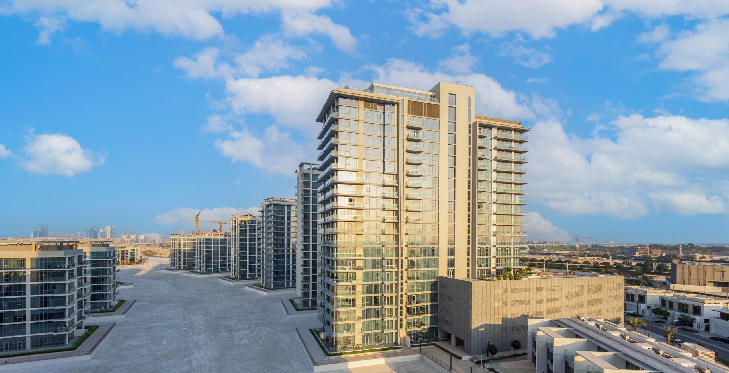 A modern high-rise building with multiple floors, large windows, and a flat roof.