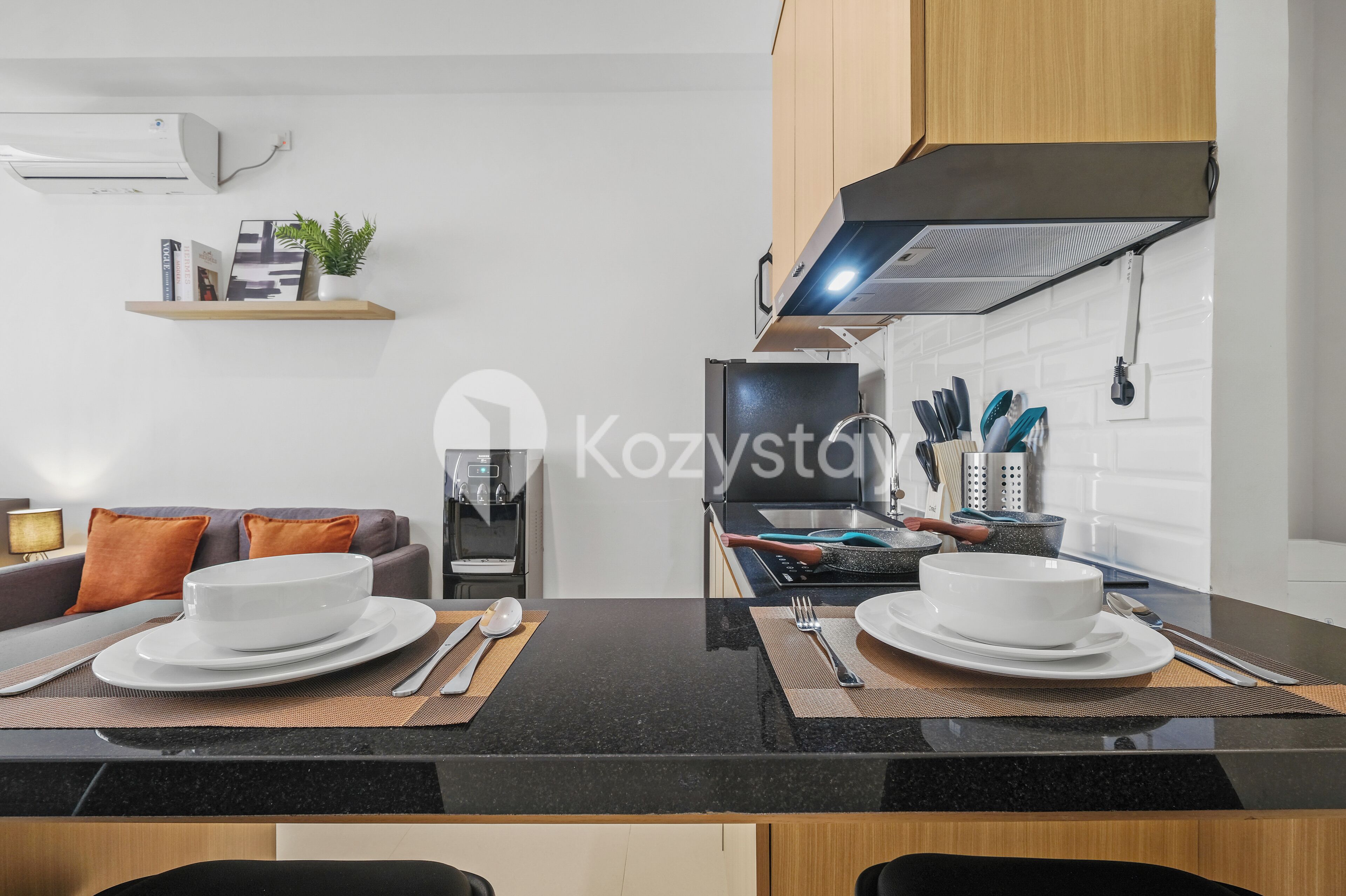 A modern kitchen with a black countertop, white cabinets, and a built-in oven.