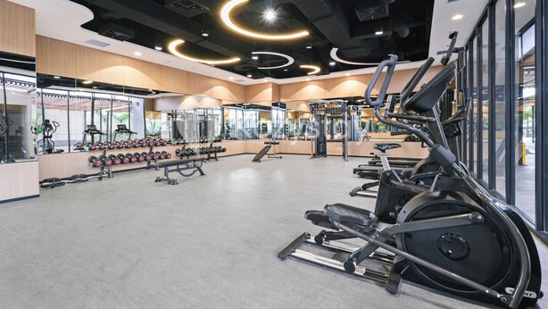 A modern gym with cardio equipment, weight machines, and free weights. - Hesrin by Kozystay - Sentul (Bogor)