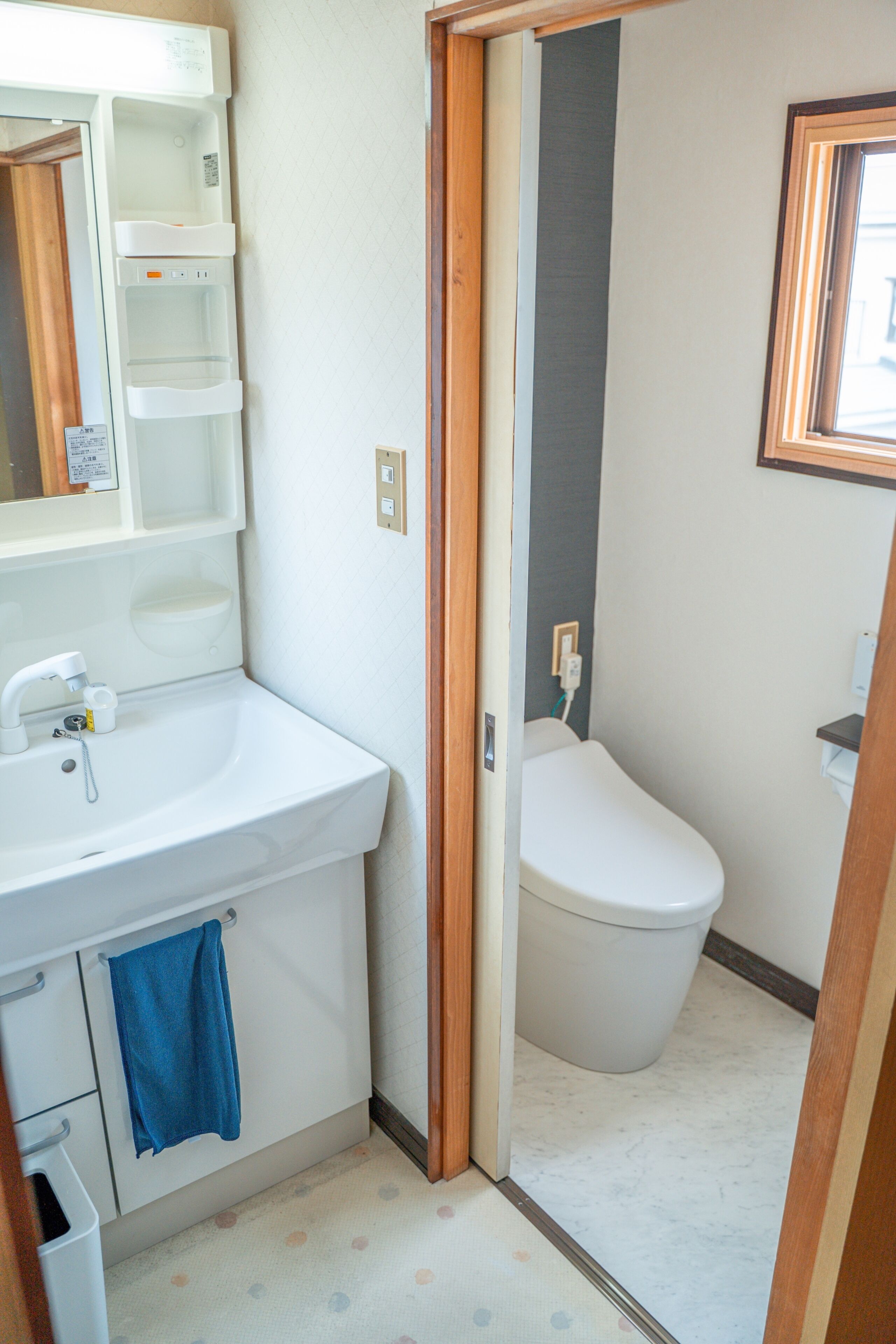 Un baño pequeño con lavamanos blanco, inodoro y espejo.