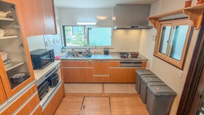 A compact kitchen with wooden cabinets, a built-in microwave, a sink, and a window.