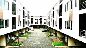 Um edifício residencial moderno com vários andares e um pátio central.