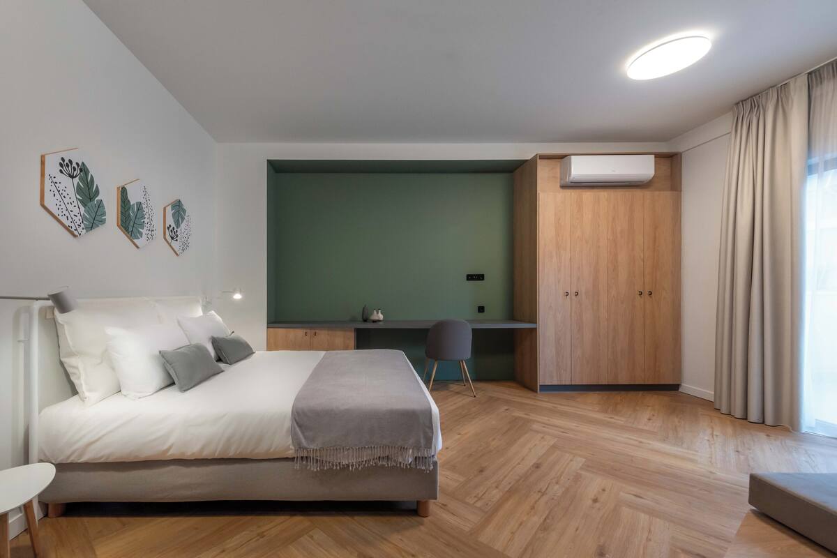 A modern bedroom with a bed, desk, and wardrobe.