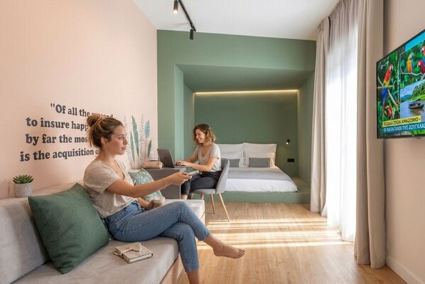 Suite – design, byutsikt | Oppholdsområde | En 42-tommers smart-TV med digitale kanaler samt Netflix og bøker