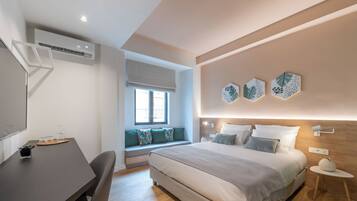 Een moderne slaapkamer met een groot bed, een bureau en een raam met uitzicht.