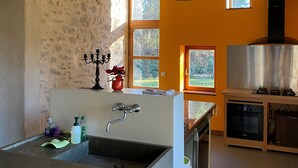 Eine moderne Küche mit Spüle, Holzbalken und einem großen Fenster.