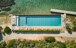 An aerial view of a rectangular swimming pool with a wooden deck and lounge chairs. - Beautiful apartment in Biograd with sauna (Biograd)
