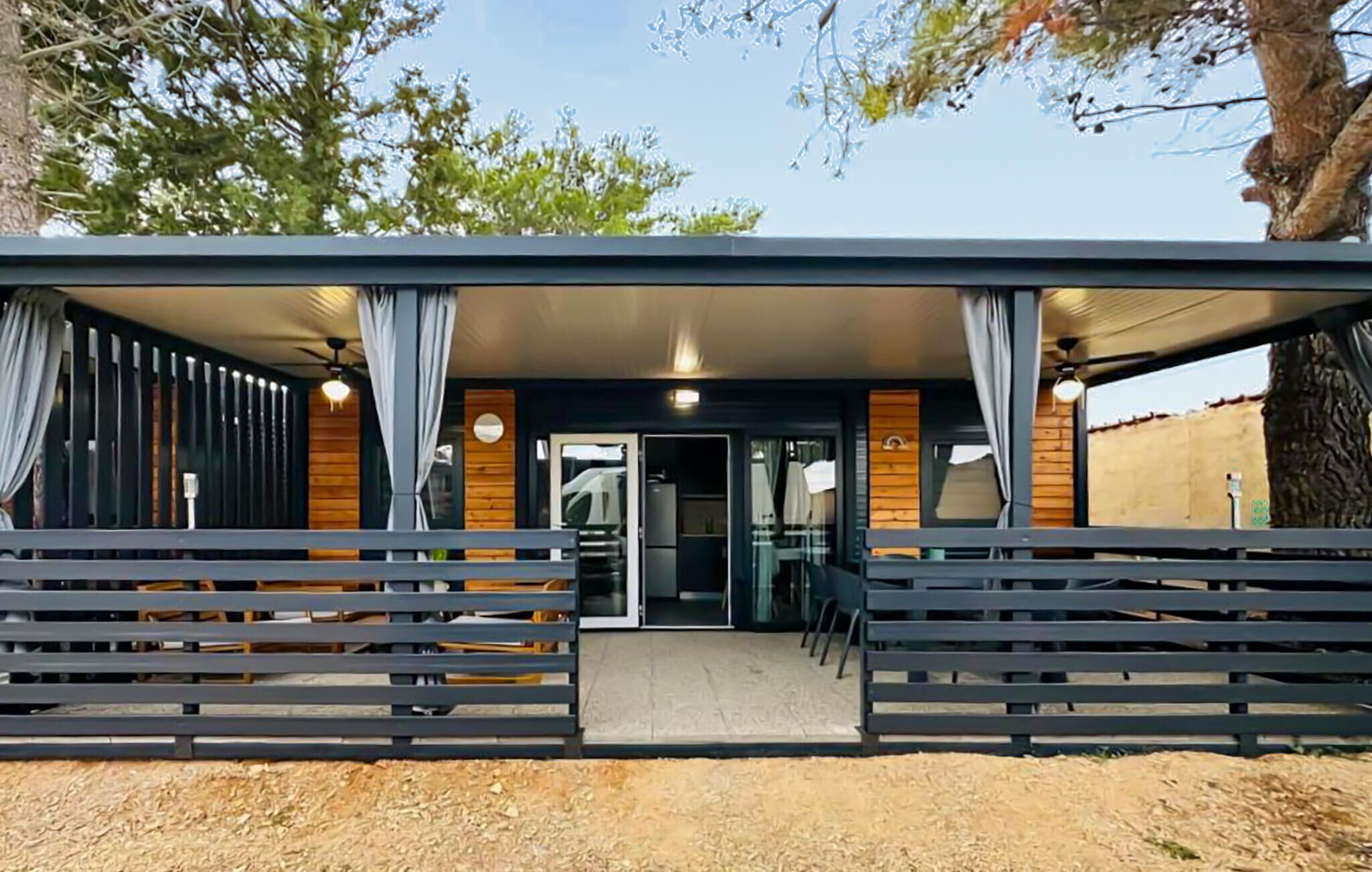 A modern building with a covered entrance, wooden walls, and a seating area with benches.
