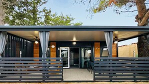 A modern building with a covered entrance, wooden walls, and a seating area with benches. - 2 bedroom lovely home in Privlaka (Privlaka)
