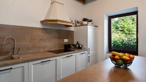 A kitchen with white cabinets, a wooden countertop, a sink, and a window with a view of greenery. - 3 bedroom lovely apartment in Lokve (Lokve)