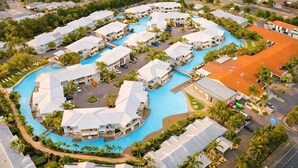 A resort with multiple buildings, a central swimming pool, and surrounding greenery. - The Oaks Pacific Blue 1 Bedroom Apartment (Salamander Bay)