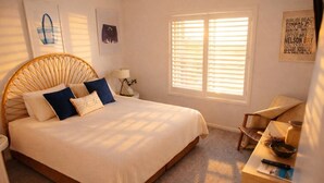 A bedroom with a large bed, a bedside table, a chair, and a window with blinds. - The Oaks Pacific Blue 1 Bedroom Apartment (Salamander Bay)