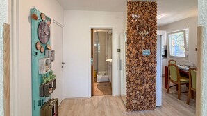 A hallway with a wooden log wall, a door with a 'HOME' sign, and a dining area with chairs and a table. - Beautiful home in Drazice (Drazice)