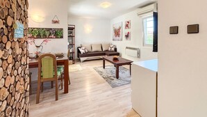 A cozy living room with a wooden dining table, a sofa, and a coffee sign on the wall. - Beautiful home in Drazice (Drazice)