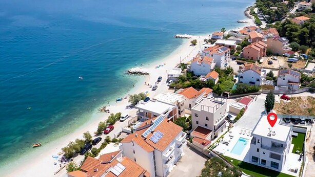 An aerial view of a coastal area with buildings, a beach, and a clear blue sea. - Stunning home in Slatine (Slatine)