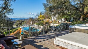 A wooden deck with outdoor seating, a hot tub, and a view of a mountain and pool. - Secluded 4BDR Retreat w/ Pool, Hot Tub, Views | Shiloh Vista Estate by AvantStay (Santa Rosa)
