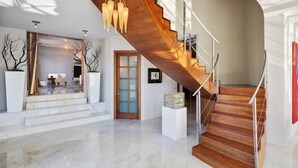 A modern interior with a wooden staircase, marble flooring, and a glass door leading to another room. - Secluded 4BDR Retreat w/ Pool, Hot Tub, Views | Shiloh Vista Estate by AvantStay (Santa Rosa)