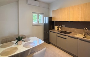 Una cocina pequeña con refrigerador, pileta y armarios de madera.