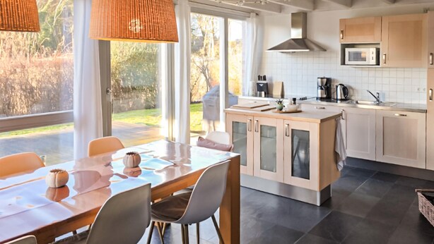 A modern kitchen with a dining area, large windows, and a view of the outdoors. - Gorgeous home in Röbel with sauna (Röbel)
