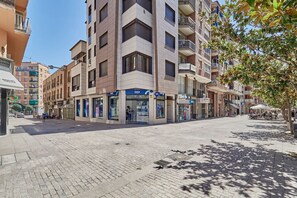 A modern building with multiple floors, featuring a ground-floor shop with a blue sign. - Nuevo apartamento Centro Lleida (Lleida)