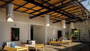 A covered outdoor seating area with wooden furniture and a concrete floor. - Surfing Elephant Resort (Polhena, Matara)