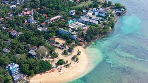An aerial view of a coastal residential area with houses, a beach, and clear turquoise waters. - Surfing Elephant Resort (Polhena, Matara)