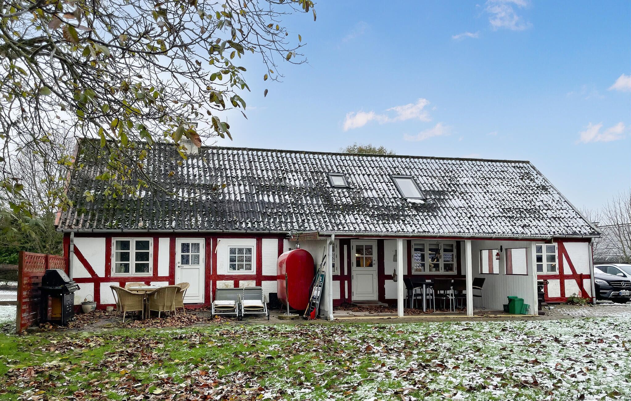 A traditional building with a tiled roof and a porch with outdoor seating.
