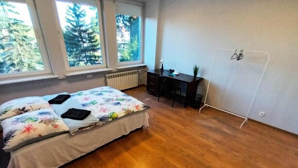 Un dormitorio con cama, escritorio y radiador.