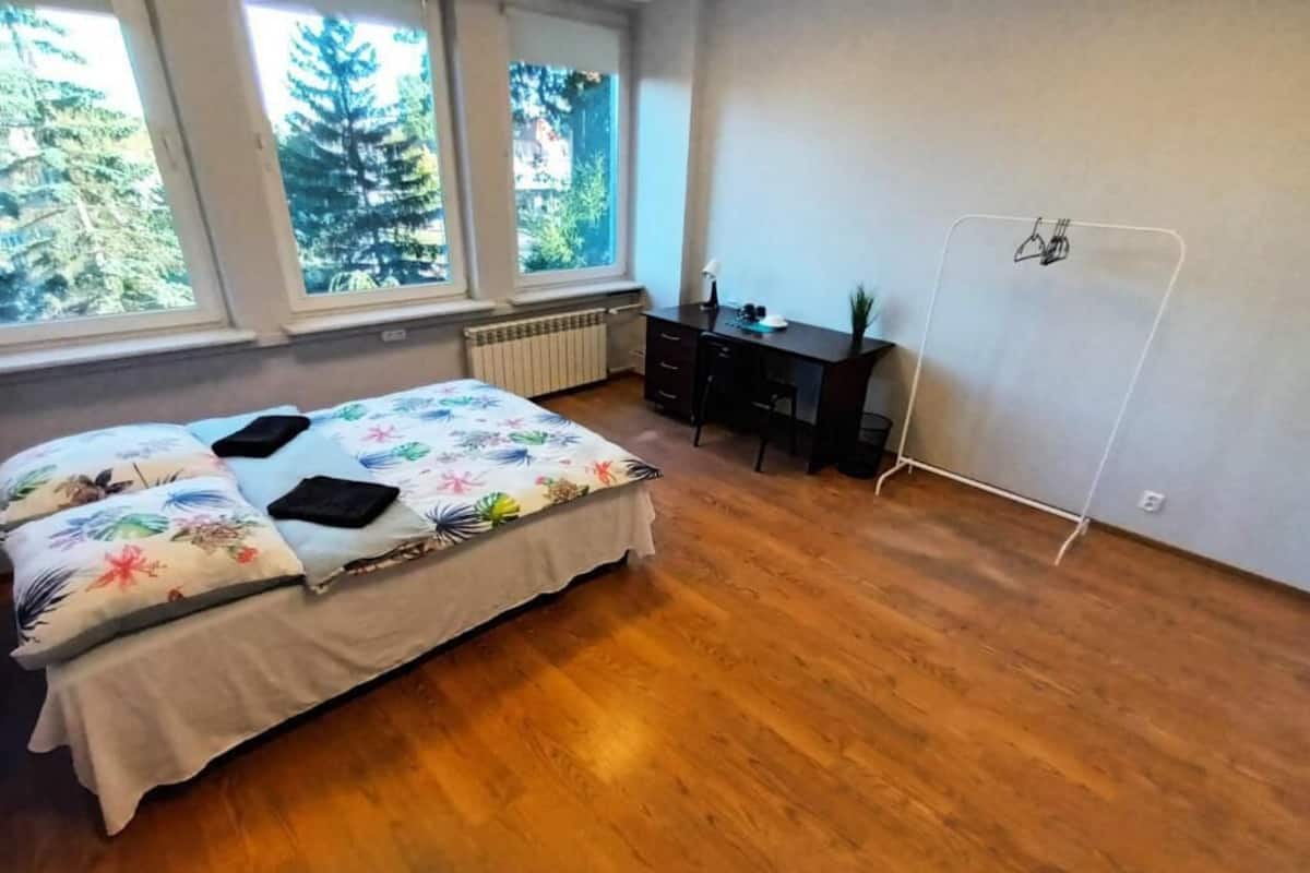 Ein Schlafzimmer mit einem Bett, einem Schreibtisch und einer Heizung.