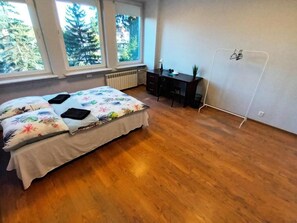 Een slaapkamer met een bed, bureau en radiator.