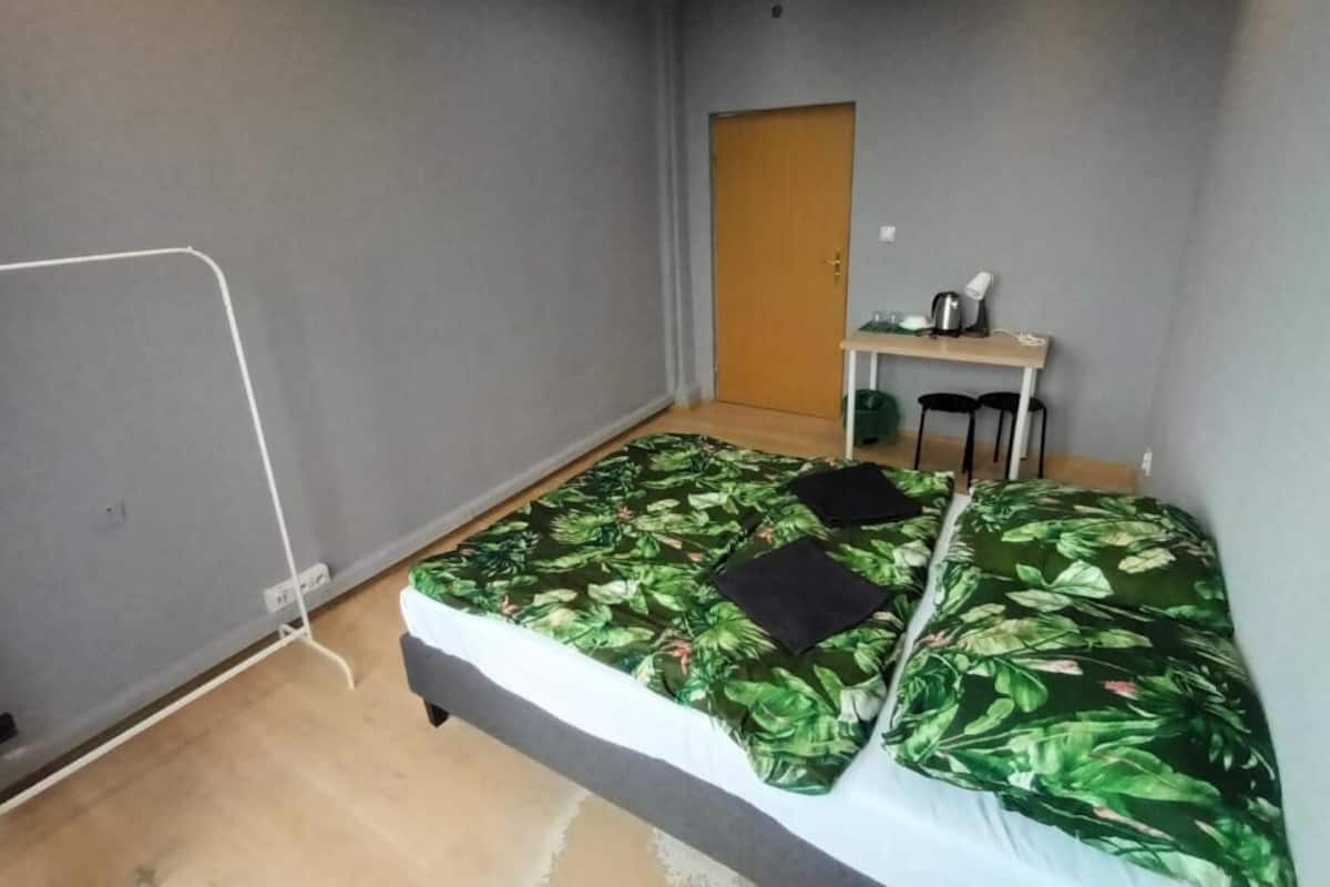 Ein kleines Hotelzimmer mit einem Bett, einem Schreibtisch und einem Stuhl.